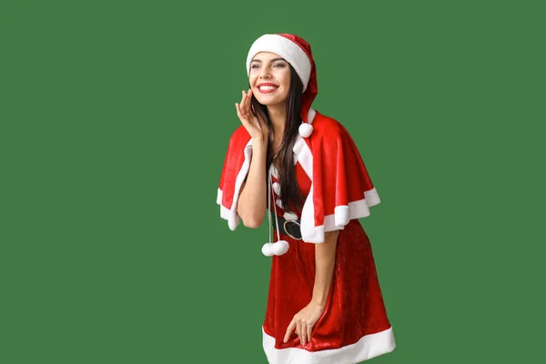 Bella giovane donna in costume di Babbo Natale su sfondo di colore — Foto Stock