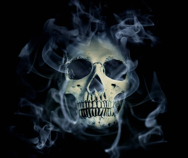 Human skull with smoke on dark background