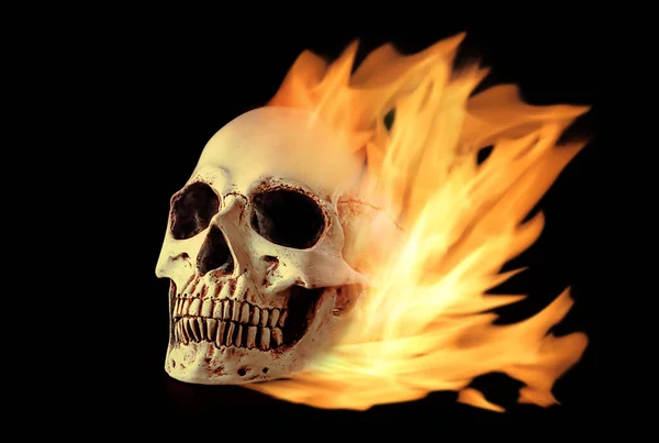 在黑暗背景下燃烧的人类头骨 — 图库照片