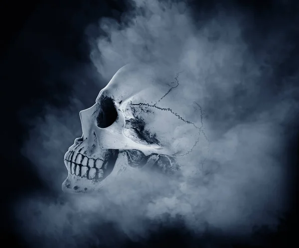 Crânio humano com fumaça no fundo escuro — Fotografia de Stock