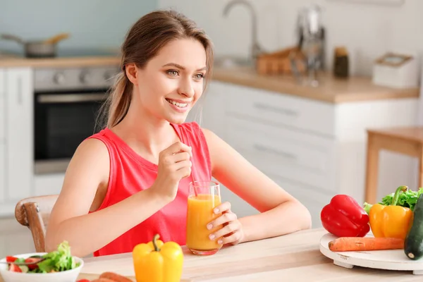 Jovem mulher bebendo suco saudável na cozinha. Conceito de dieta — Fotografia de Stock