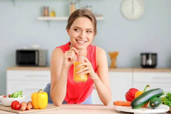 Mujer joven bebiendo jugo saludable en la cocina. Concepto de dieta —  Fotos de Stock