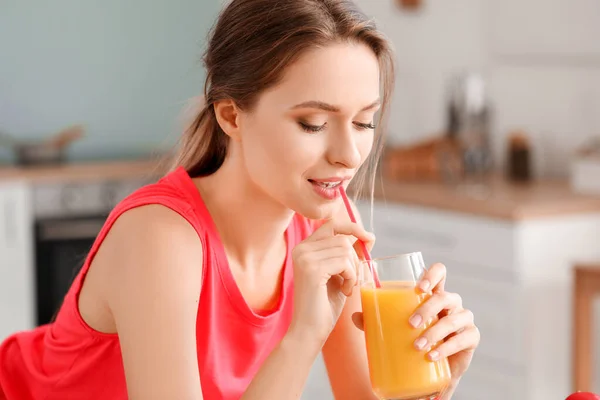 Young woman drinking healthy juice in kitchen. Diet concept — Stock Photo, Image