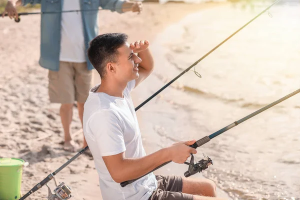 Joven y su padre pescando en el río — Foto de Stock