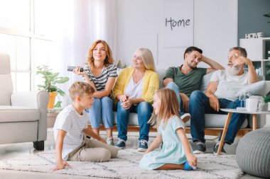 Büyük aile evde birlikte Tv izliyor