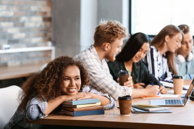 Okuma odasında oturan arkadaşları ile Afrikalı-Amerikalı öğrenci