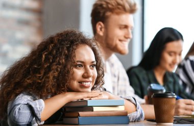 Okuma odasında oturan arkadaşları ile Afrikalı-Amerikalı öğrenci