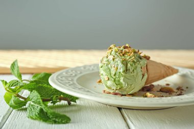 Lezzetli fıstıklı dondurma tabağı beyaz masanın üstünde.