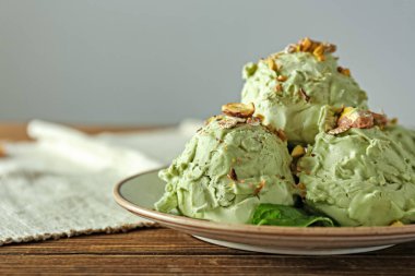 Ahşap masada fıstıklı dondurma tabağı.