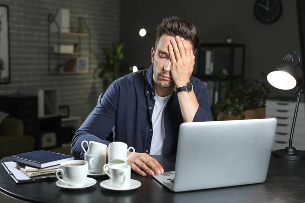 Tired man trying to meet deadline in office — Stock Photo, Image
