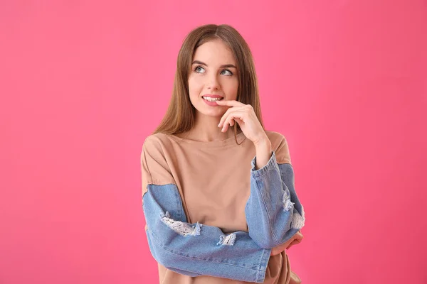 Tänksam ung kvinna på färg bakgrund — Stockfoto