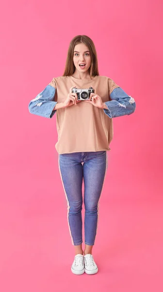 Красивая девушка с фотокамерой на цветном фоне — стоковое фото