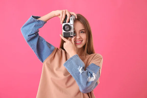 Красивая девушка с фотокамерой на цветном фоне — стоковое фото