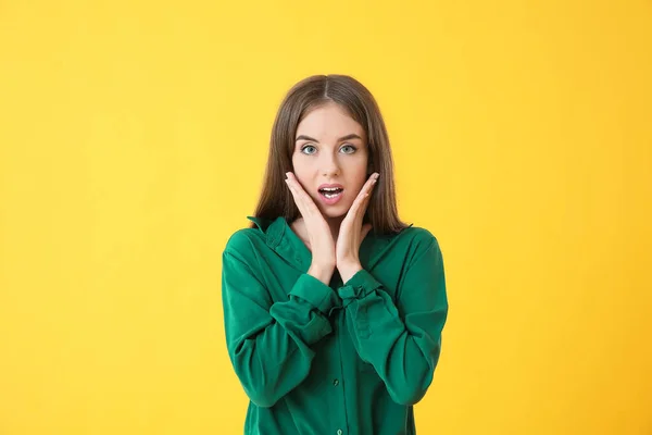 Mujer joven sorprendida sobre fondo de color —  Fotos de Stock