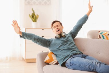 Kulaklıklı yakışıklı adam evde dinleniyor.