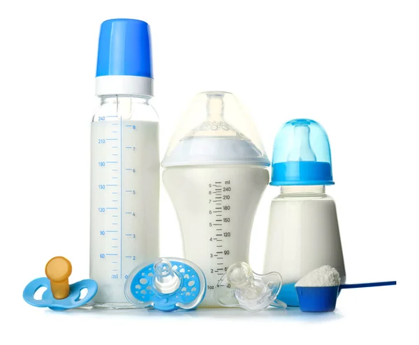 Bottles of milk with pacifiers and baby formula on white background — Stock Photo, Image