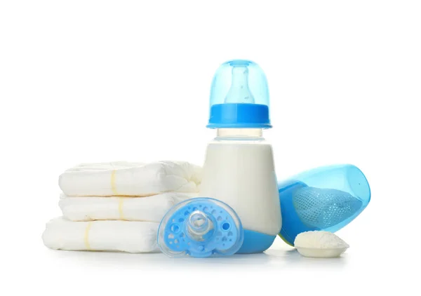 Biberón de leche maternizada con chupete, pañales y mordisquitos sobre fondo blanco — Foto de Stock