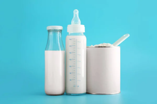 Bottles of milk with baby formula on color background