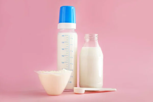 Milchflaschen mit Babynahrung auf farbigem Hintergrund — Stockfoto