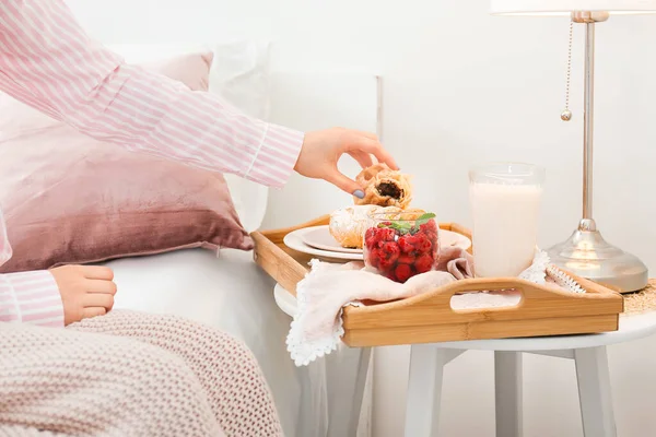 Junge Frau frühstückt lecker im Bett — Stockfoto