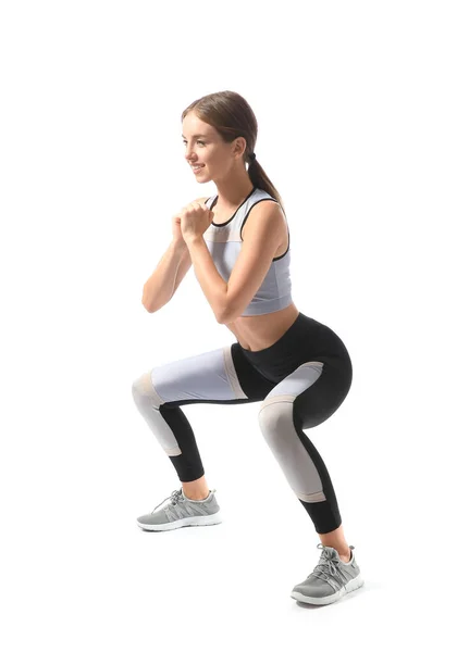 Sportliche junge Frau trainiert vor weißem Hintergrund — Stockfoto