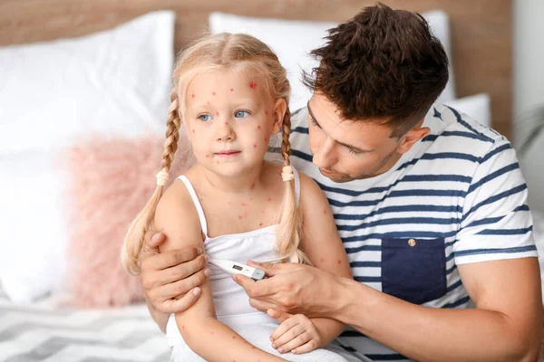 Muž měří teplotu své dcery nemocné s neštovicemi doma — Stock fotografie
