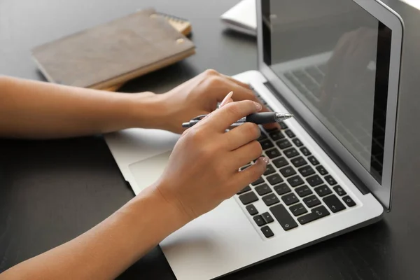 Junge Frau arbeitet am Laptop am Tisch — Stockfoto