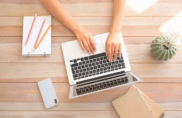 Jovem mulher trabalhando no laptop à mesa — Fotografia de Stock