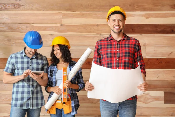 Portrait of male architect and his team on wooden background — Stock Photo, Image