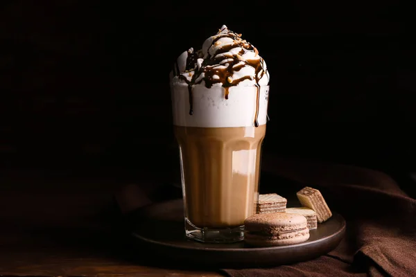 Glas lekkere frappe koffie met zoetigheden op houten tafel — Stockfoto