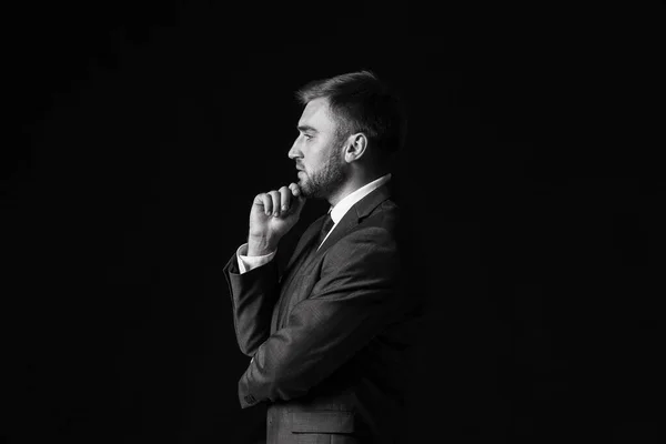 Black and white portrait of handsome businessman on dark background — Stock Photo, Image