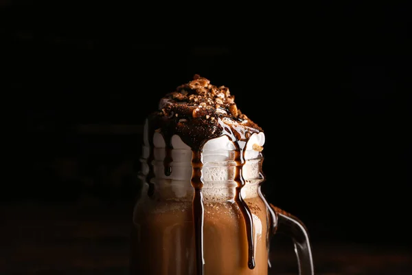 Einmachglas mit leckerem Frappé-Kaffee auf dunklem Hintergrund, Nahaufnahme — Stockfoto