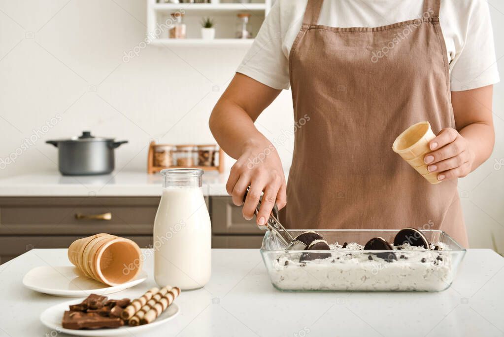 Woman preparing tasty ice cream in kitchen