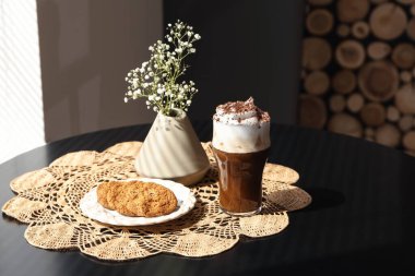 Kafedeki masada kurabiyeli bir bardak lezzetli frappe kahve.