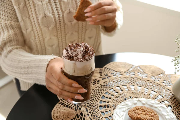 Mujer bebiendo sabroso frappe café con galletas en la cafetería —  Fotos de Stock