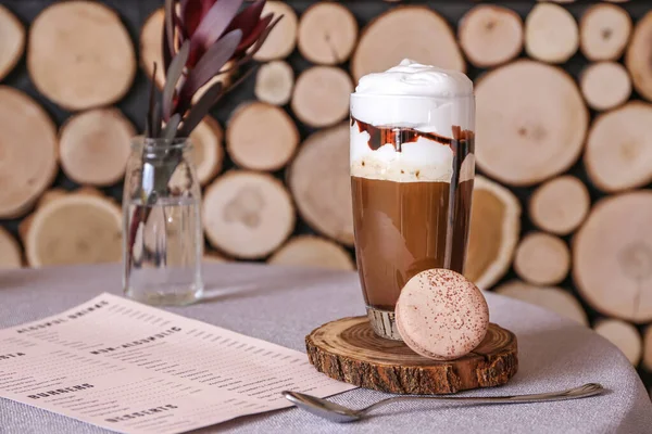 Стакан вкусного кофе фраппе с меню на столе в кафе — стоковое фото