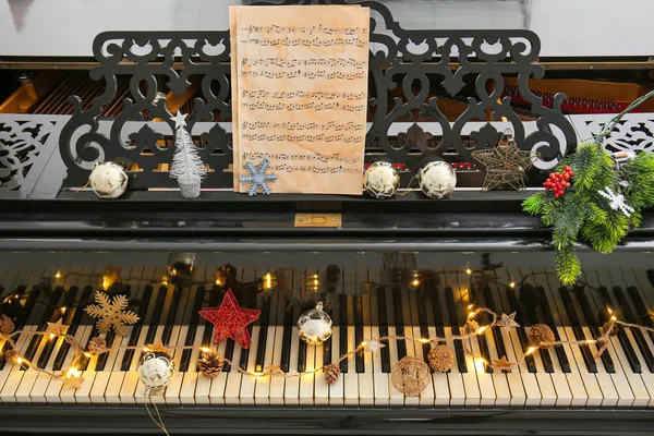 Piano met kerstdecor en bladmuziek — Stockfoto