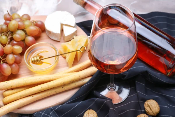 Стакан вкусного вина с закусками на столе — стоковое фото