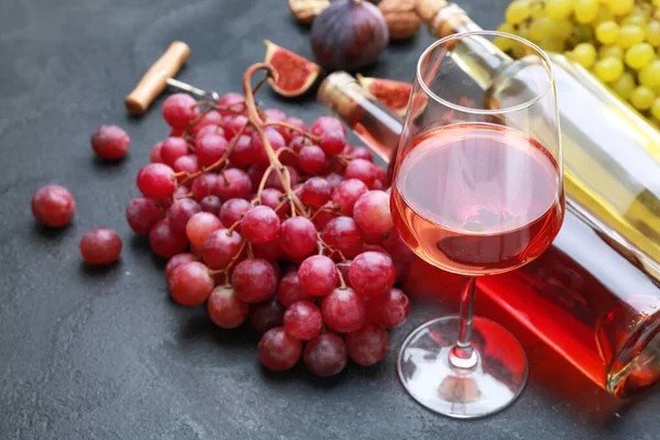 Вкусное вино с виноградом на темном фоне — стоковое фото