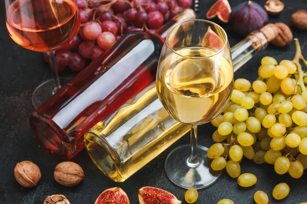 Различные вкусное вино с виноградом на темном фоне — стоковое фото