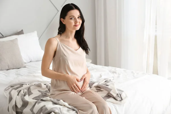 Mooie jonge zwangere vrouw in slaapkamer — Stockfoto