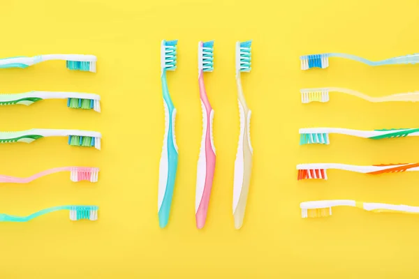 Different tooth brushes on color background — Stock Photo, Image