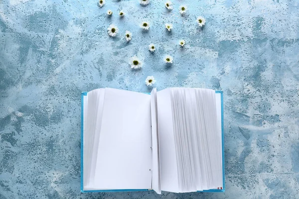 Open book with flowers on color background — Stock Photo, Image