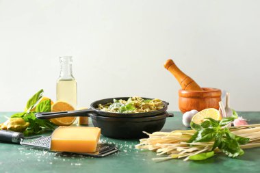 Kızartma tavası, lezzetli makarna ve malzemeler masada.