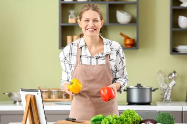 Mutfakta yemek pişiren güzel genç bir kadın.