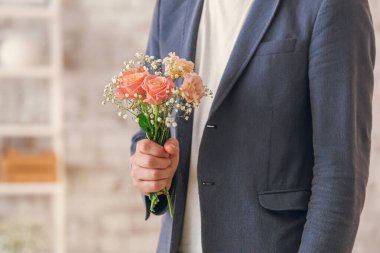 Kapalı alanda güzel bir buketi olan adam, yakın plan.