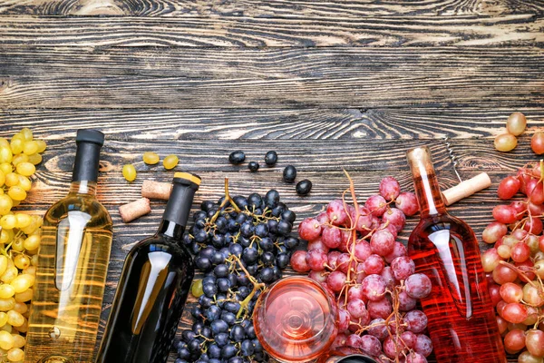 Flaschen mit verschiedenen Weinen auf Holztisch — Stockfoto