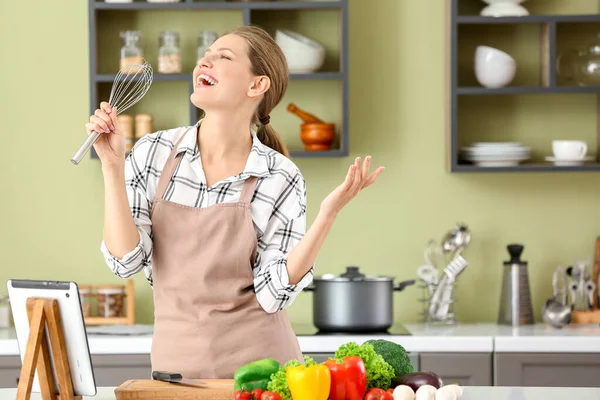 Mutfakta yemek yaparken güzel genç kadın şarkı — Stok fotoğraf
