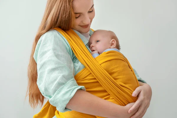 Young mother with little baby in sling on white background — Stock Photo, Image