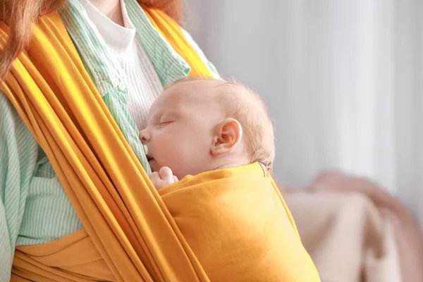 Young mother with little baby in sling at home, closeup — Stock Photo, Image